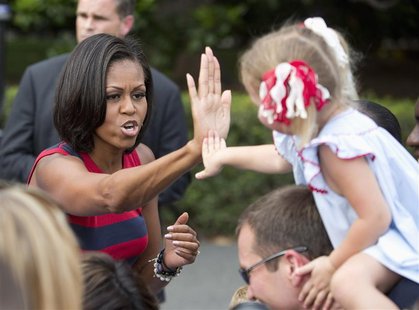 First Lady Michelle Obama high-fives a child during Independence Day celebrations on the South Lawn of the White House in Washington July 4, First Lady Michelle Obama high-fives a child during Independence Day celebrations on the South Lawn of the White House in Washington July 4,