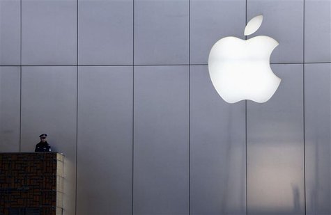 A policeman looks out from a balcony as the crowd is dispersed from the front of an Apple store in the Beijing district of Sanlitun in this A policeman looks out from a balcony as the crowd is dispersed from the front of an Apple store in the Beijing district of Sanlitun in this