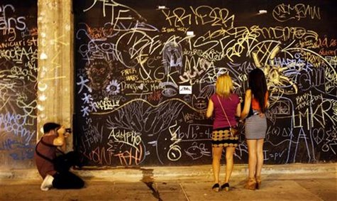 Two women look at chalk graffiti during art walk in Downtown Los Angeles, California July 12, 2012. REUTERS/Sam Mircovich Two women look at chalk graffiti during art walk in Downtown Los Angeles, California July 12, 2012. REUTERS/Sam Mircovich