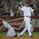New York Yankees shortstop Derek Jeter and Los Angeles Angels runner Howard Kendrick (L) react after Jeter caught Kendrick trying to steal s