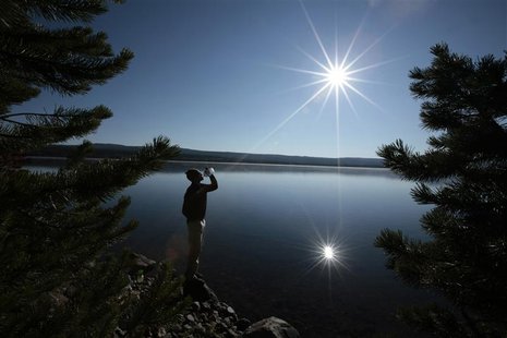 A hiker drinks from a water bottle in front of Heart Lake in the Red Mountains of Yellowstone National Park, Wyoming August 10, 2011. REUTER A hiker drinks from a water bottle in front of Heart Lake in the Red Mountains of Yellowstone National Park, Wyoming August 10, 2011. REUTER