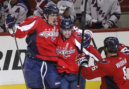 Washington Capitals' Mike Green (C) celebrates with teammates Alex Ovechkin (L) and Dennis Wideman after he scored the game winning goal dur Washington Capitals' Mike Green (C) celebrates with teammates Alex Ovechkin (L) and Dennis Wideman after he scored the game winning goal dur