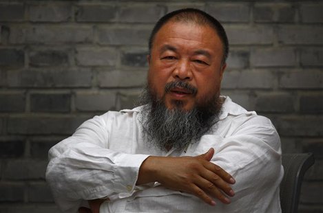 Chinese dissident artist Ai Weiwei folds his arms as he sits on a chair in the courtyard of his studio in Beijing June 20, 2012. REUTERS/Dav Chinese dissident artist Ai Weiwei folds his arms as he sits on a chair in the courtyard of his studio in Beijing June 20, 2012. REUTERS/Dav