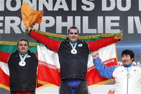 Gold medallist Behdad Salimikordasiabi (C) of Iran celebrates on the podium with silver medallist Sajjad Anoushiravani Hamlabad (L) of Iran Gold medallist Behdad Salimikordasiabi (C) of Iran celebrates on the podium with silver medallist Sajjad Anoushiravani Hamlabad (L) of Iran
