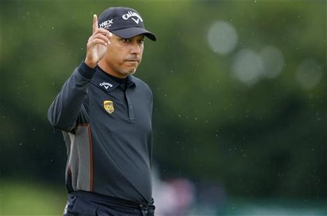 Jeev Milkha Singh acknowledges the crowd after making his birdie putt on the first green during the first round of the British Open golf cha Jeev Milkha Singh acknowledges the crowd after making his birdie putt on the first green during the first round of the British Open golf cha