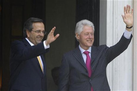 Greek Prime Minister Antonis Samaras (L) and visiting Former U.S. President Bill Clinton wave to reporters during their meeting in Athens Ju Greek Prime Minister Antonis Samaras (L) and visiting Former U.S. President Bill Clinton wave to reporters during their meeting in Athens Ju