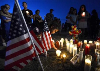 Myia Young, 4, places a candle by an American flag during a vigil for victims behind a theater where a gunman open fire at moviegoers in Aurora, Colorado July 20, 2012.
Credit: REUTERS/ Jeremy Papasso Myia Young, 4, places a candle by an American flag during a vigil for victims behind a theater where a gunman open fire at moviegoers in Aurora, Colorado July 20, 2012.
Credit: REUTERS/ Jeremy Papasso
