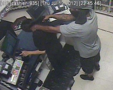 An armed robber points a gun at a clerk in the Family Fare gas station on Washington Ave. around 10:30 PM on July 12, 2012. (photo courtesy Holland Dept. of Public Safety)