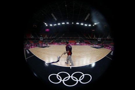 A worker sweeps the court before a training session at the Basketball Arena before the start of the London 2012 Olympic Games July 26, 2012. A worker sweeps the court before a training session at the Basketball Arena before the start of the London 2012 Olympic Games July 26, 2012.