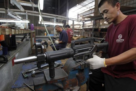 A former illegal gunsmith inspects a newly assembled multi-action shotgun at Shooters Arms, a gun manufacturing company exporting different A former illegal gunsmith inspects a newly assembled multi-action shotgun at Shooters Arms, a gun manufacturing company exporting different