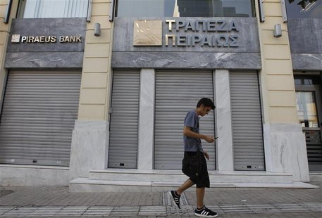 A man walks outside of a closed Piraeus bank branch in central Athens July 16, 2012. REUTERS/John Kolesidis A man walks outside of a closed Piraeus bank branch in central Athens July 16, 2012. REUTERS/John Kolesidis
