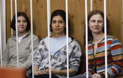 Members of female punk band "Pussy Riot", Nadezhda Tolokonnikova (C), Maria Alyokhina (R) and Yekaterina Samutsevich, sit behind bars before Members of female punk band "Pussy Riot", Nadezhda Tolokonnikova (C), Maria Alyokhina (R) and Yekaterina Samutsevich, sit behind bars before