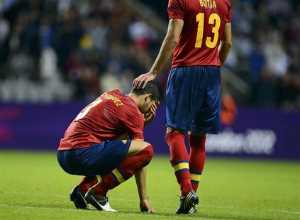 Spain's Alberto Botia consoles his team mate Alvaro Dominguez (L) after losing their men's Group D football match against Honduras in the Lo Spain's Alberto Botia consoles his team mate Alvaro Dominguez (L) after losing their men's Group D football match against Honduras in the Lo