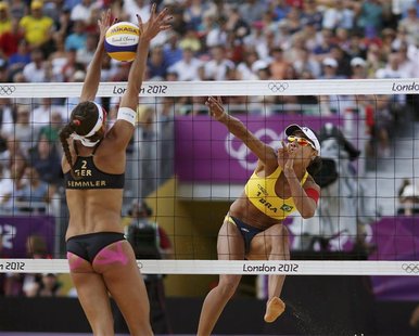 Brazil's Juliana spikes the ball as Germany's Ilka Semmler (L) blocks it during their women's preliminary round beach volleyball match at th Brazil's Juliana spikes the ball as Germany's Ilka Semmler (L) blocks it during their women's preliminary round beach volleyball match at th