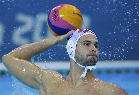 Croatia's Ivan Buljubasic controls the ball during their men's preliminary round Group A water polo match against Spain at the Water Polo Ar Croatia's Ivan Buljubasic controls the ball during their men's preliminary round Group A water polo match against Spain at the Water Polo Ar