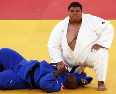 Guam's Ricardo Blas Jr. (R) looks up after winning his men's +100kg elimination round of 32 judo match against Guinea's Facinet Keita at the Guam's Ricardo Blas Jr. (R) looks up after winning his men's +100kg elimination round of 32 judo match against Guinea's Facinet Keita at the