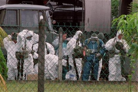 Malaysian soldiers prepare their protective gear prior to the slaughter of pigs at a farm in Sungai Nipah, 100 kilometres (60 miles) southwe Malaysian soldiers prepare their protective gear prior to the slaughter of pigs at a farm in Sungai Nipah, 100 kilometres (60 miles) southwe