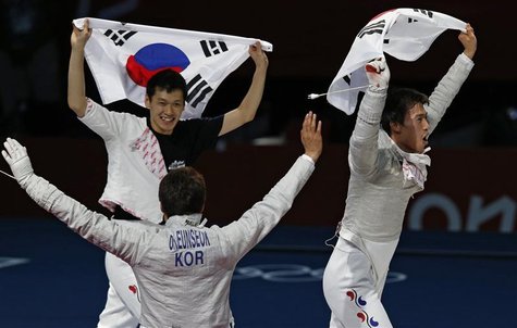 (L-R) South Korea's Bongil Gu, Eunseok Oh and Woo Young Won celebrate with their national flag winning at the end of their men's sabre team (L-R) South Korea's Bongil Gu, Eunseok Oh and Woo Young Won celebrate with their national flag winning at the end of their men's sabre team