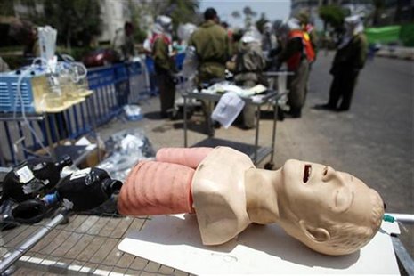 A mannequin used to teach cardiopulmonary resuscitation (CPR) techniques is seen next to rescue teams as they take part in a drill simulatin A mannequin used to teach cardiopulmonary resuscitation (CPR) techniques is seen next to rescue teams as they take part in a drill simulatin