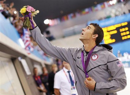 Michael Phelps of the U.S. throws his winner's flower bouquet to his mother Debbie (not pictured), after receiving his gold medal for winnin Michael Phelps of the U.S. throws his winner's flower bouquet to his mother Debbie (not pictured), after receiving his gold medal for winnin
