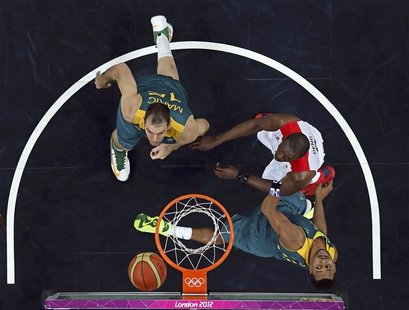 Australia's Patrick Mills (R) watches his shot with teammate Australia's Aleks Maric (L) and Great Britain's Luol Deng (C) during their men' Australia's Patrick Mills (R) watches his shot with teammate Australia's Aleks Maric (L) and Great Britain's Luol Deng (C) during their men'