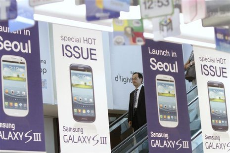 A man standing on an escalator passes Samsung Electronics' new Galaxy S III smartphone advertisement boards at a Samsung Electronics store i A man standing on an escalator passes Samsung Electronics' new Galaxy S III smartphone advertisement boards at a Samsung Electronics store i