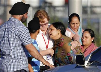 A distraught women is helped to a car outside of the Sikh temple in Oak Creek, Wisconsin August 5, 2012. REUTERS/Tom Lynn A distraught women is helped to a car outside of the Sikh temple in Oak Creek, Wisconsin August 5, 2012. REUTERS/Tom Lynn