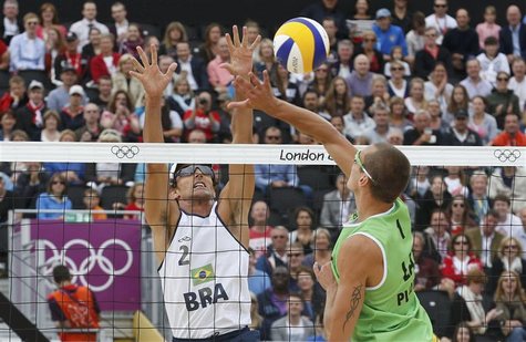 Brazil's Emanuel (L) block a spike from Latvia's Martins Plavins during the men's beach volleyball semifinal match at Horse Guards Parade du Brazil's Emanuel (L) block a spike from Latvia's Martins Plavins during the men's beach volleyball semifinal match at Horse Guards Parade du