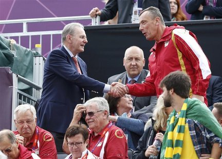 International Olympic Committee President Jacques Rogge (top L) greets an Olympic official as he and his wife Anne (seated C) arrive to watc International Olympic Committee President Jacques Rogge (top L) greets an Olympic official as he and his wife Anne (seated C) arrive to watc