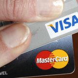 A credit card user displays her cards in Washington February 22, 2010. REUTERS/Kevin Lamarque