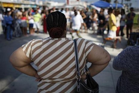 An overweight woman watches a street performer at Venice Beach in Los Angeles, California, May 11, 2012. REUTERS/David McNew An overweight woman watches a street performer at Venice Beach in Los Angeles, California, May 11, 2012. REUTERS/David McNew