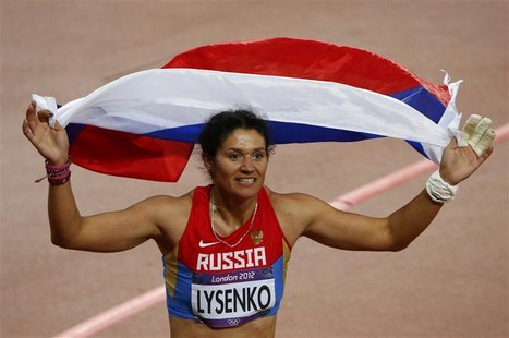 Russia's Tatyana Lysenko smiles as she celebrates with her national flag after winning the gold medal in the women's hammer throw final at t Russia's Tatyana Lysenko smiles as she celebrates with her national flag after winning the gold medal in the women's hammer throw final at t