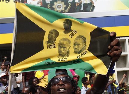 A Jamaican man holds a flag showing the faces of Jamaica's Usain Bolt, Nesta Carter, Michael Frater and Yohan Blake after Jamaica wins the m A Jamaican man holds a flag showing the faces of Jamaica's Usain Bolt, Nesta Carter, Michael Frater and Yohan Blake after Jamaica wins the m
