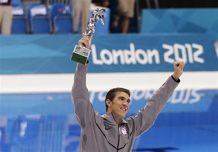 Michael Phelps of the U.S. celebrates with his trophy awarded to him by FINA honouring him as the most decorated Olympian of all time, after Michael Phelps of the U.S. celebrates with his trophy awarded to him by FINA honouring him as the most decorated Olympian of all time, after