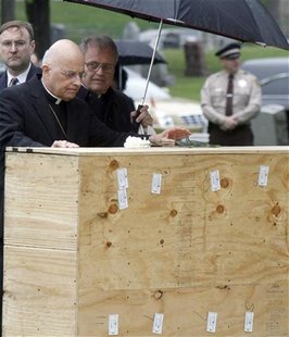 Chicago Cardinal Francis George (C) offers a graveside blessing to the remains of indigent people at Mt. Olivet cemetery on the southwest si Chicago Cardinal Francis George (C) offers a graveside blessing to the remains of indigent people at Mt. Olivet cemetery on the southwest si