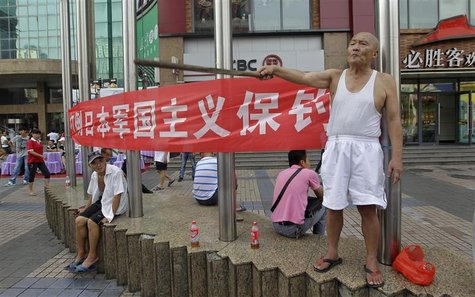 A protester (R) yells anti-Japan slogans as he holds a stick in front of a banner on a commercial street in Wuhan, Hubei province August 18, A protester (R) yells anti-Japan slogans as he holds a stick in front of a banner on a commercial street in Wuhan, Hubei province August 18,