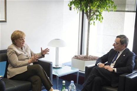 German Chancellor Angela Merkel (L) talks with European Central Bank (ECB) President Mario Draghi before a European Union leaders summit in German Chancellor Angela Merkel (L) talks with European Central Bank (ECB) President Mario Draghi before a European Union leaders summit in