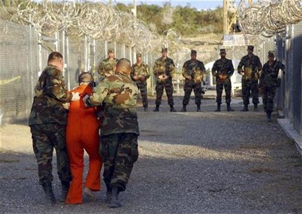 U.S. Army Military Police escort a detainee to his cell during in-processing to the temporary detention facility at Camp X-Ray in Naval Base U.S. Army Military Police escort a detainee to his cell during in-processing to the temporary detention facility at Camp X-Ray in Naval Base