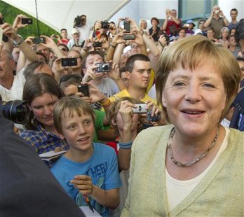 Visitors surround German Chancellor Angela Merkel (R) during open house day at the Chancellery in Berlin, August 19, 2012. REUTERS/Thomas Pe Visitors surround German Chancellor Angela Merkel (R) during open house day at the Chancellery in Berlin, August 19, 2012. REUTERS/Thomas Pe