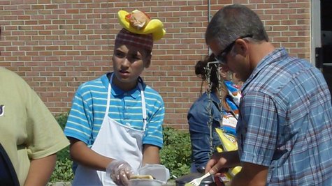 Nathan Duszynski serves a hot dog on the first day of his vending cart sales on River Avenue across 11th Street from Holland City Hall on Aug. 23, 2012. Nathan Duszynski serves a hot dog on the first day of his vending cart sales on River Avenue across 11th Street from Holland City Hall on Aug. 23, 2012.