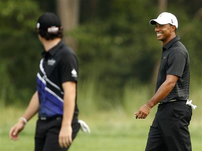 Tiger Woods (R) of the U.S. and Rory McIlory of Northern Ireland talk as they walk up the 13th fairway during the first round of the PGA gol Tiger Woods (R) of the U.S. and Rory McIlory of Northern Ireland talk as they walk up the 13th fairway during the first round of the PGA gol