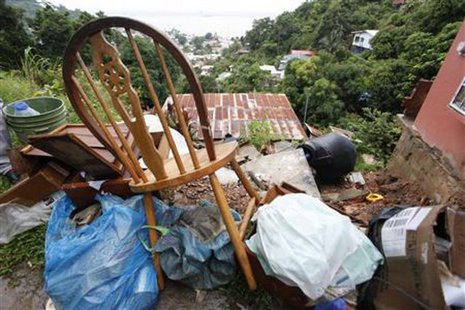 Furniture and other belongings are stacked outside as a resident prepares to move out of a house damaged by a mudslide caused by the passing of Tropical Storm Isaac at Upper Neckles Drive, Carenage August 23, 2012. REUTERS/Andrea De Silva Furniture and other belongings are stacked outside as a resident prepares to move out of a house damaged by a mudslide caused by the passing of Tropical Storm Isaac at Upper Neckles Drive, Carenage August 23, 2012. REUTERS/Andrea De Silva