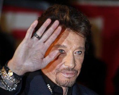 French singer Johnny Hallyday waves as he arrives at the Cannes festival palace to attend the NRJ Music Awards in Cannes January 28,2012. RE French singer Johnny Hallyday waves as he arrives at the Cannes festival palace to attend the NRJ Music Awards in Cannes January 28,2012. RE