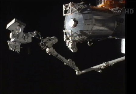 In this still image taken from video, Japan Aerospace Exploration Agency Flight Engineer Akihiko Hoshide takes a ride on the end of the spac In this still image taken from video, Japan Aerospace Exploration Agency Flight Engineer Akihiko Hoshide takes a ride on the end of the spac