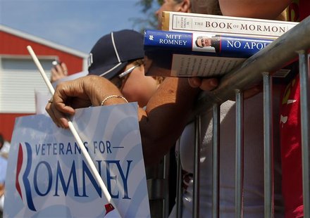A supporter holds Republican presidential candidate and former Massachusetts Governor Mitt Romney's book "No Apology" and a copy of the "Boo A supporter holds Republican presidential candidate and former Massachusetts Governor Mitt Romney's book "No Apology" and a copy of the "Boo