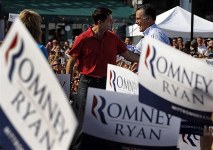 Republican presidential candidate and former Massachusetts Governor Mitt Romney takes over the microphone from vice-presidential candidate U Republican presidential candidate and former Massachusetts Governor Mitt Romney takes over the microphone from vice-presidential candidate U