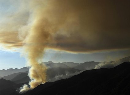 A plume of thick smoke rises from the hills above San Gabriel mountains in the Angeles National Forest, California, along Highway 39 on Azus A plume of thick smoke rises from the hills above San Gabriel mountains in the Angeles National Forest, California, along Highway 39 on Azus