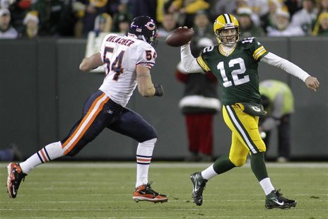 Chicago Bears linebacker Brian Urlacher (L) chases Green Bay Packers quarterback Aaron Rodgers (R) in the first half during their NFL footba Chicago Bears linebacker Brian Urlacher (L) chases Green Bay Packers quarterback Aaron Rodgers (R) in the first half during their NFL footba
