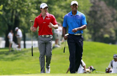 Rory McIlroy (L) of Northern Ireland talks with Tiger Woods of the U.S. as they approach the first green during round one of the BMW Champio Rory McIlroy (L) of Northern Ireland talks with Tiger Woods of the U.S. as they approach the first green during round one of the BMW Champio