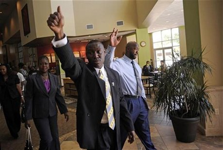 Attorney Benjamin Crump (C) waves to supporters with Tracy Martin (R) and Sabrina Fulton (L), the parents of the late Trayvon Martin, after Attorney Benjamin Crump (C) waves to supporters with Tracy Martin (R) and Sabrina Fulton (L), the parents of the late Trayvon Martin, after